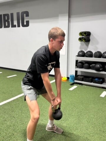 physical therapist reviewing movement screen results with an active adult patient in a performance training facility